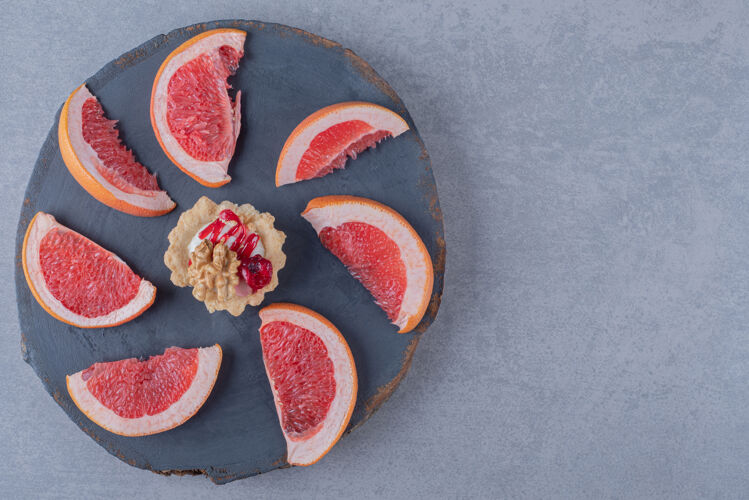 新鲜美味的饼干配柚子片在木板上健康果汁柑橘