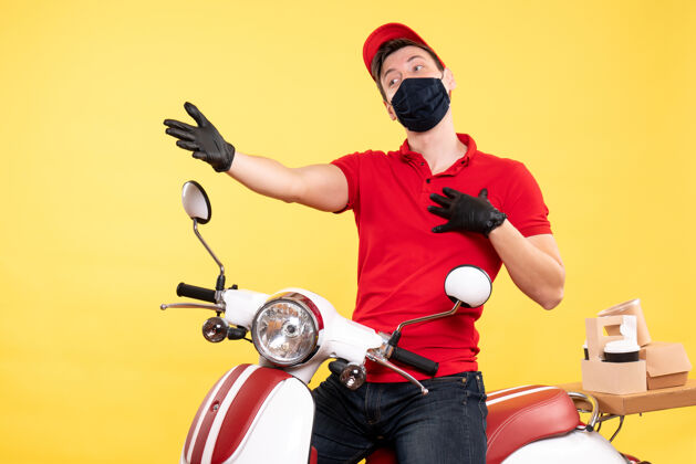 自行车正面图黄色制服上戴着手套和面罩的男信使人摩托车男信使