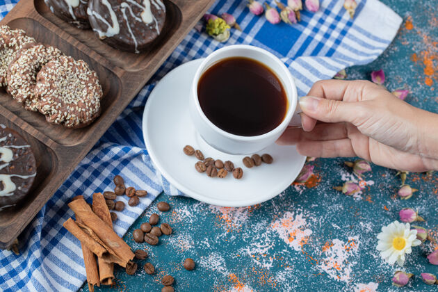 华夫饼巧克力和椰子饼干放在木板上 配上一杯茶咖啡馆肉桂美味