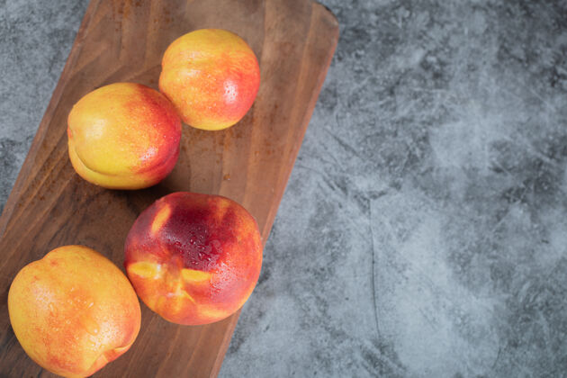 美味黄红色的桃子在木板上产品美味顶视图