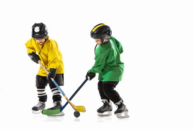 健康冰球场上拿着棍子的小冰球运动员和白色的工作室墙棍棒溜冰头盔