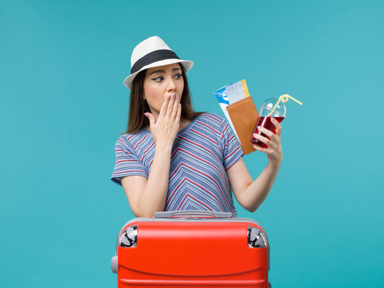 旅程前景度假中的女人拿着钱包拿着蓝色背景上的机票航海旅行女海飞机夏天女肖像票