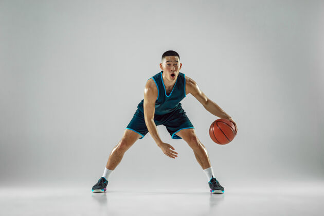 球员年轻的篮球队员穿着运动服训练 在运动中练习 在运动中奔跑隔离在白墙上健康运动射击