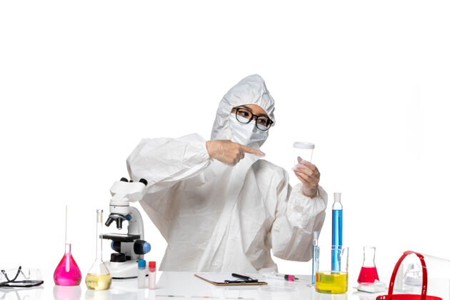 医疗正面图身穿特殊防护服的年轻女化学家拿着空瓶子在白色地板上实验室病毒-化学病毒健康化学医生套装