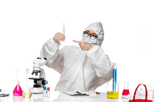 保温瓶正面图身穿特殊防护服的年轻女化学家拿着白色背景上蓝色溶液的烧瓶实验室病毒化学溶液外套医生