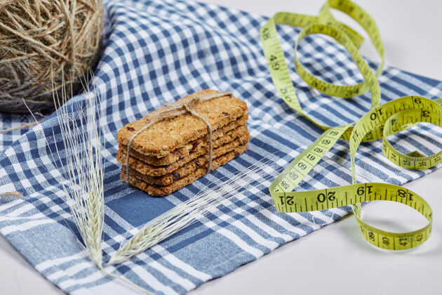 脆的饼干和卷尺放在白色桌布上 特写量具胶带食物