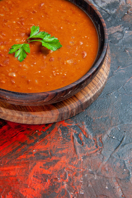 午餐番茄汤在一个棕色的切菜板上的一个混合颜色的桌子上的垂直视图一餐餐厅汤