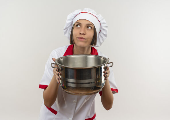 烹饪体贴的年轻女厨师 身着厨师制服 手持火锅 孤零零地仰望着白色的墙壁衣服年轻人