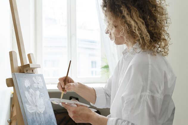 侧视图卷发女子在家画画侧视图娱乐绘画调色板