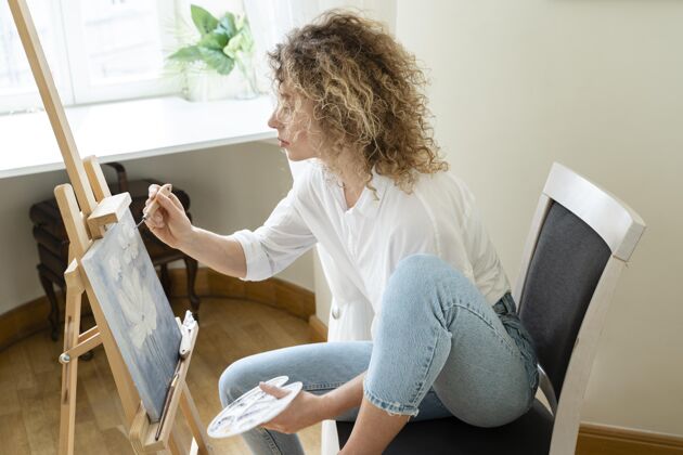 宁静卷发女子在家画画侧视图娱乐侧视图艺术家