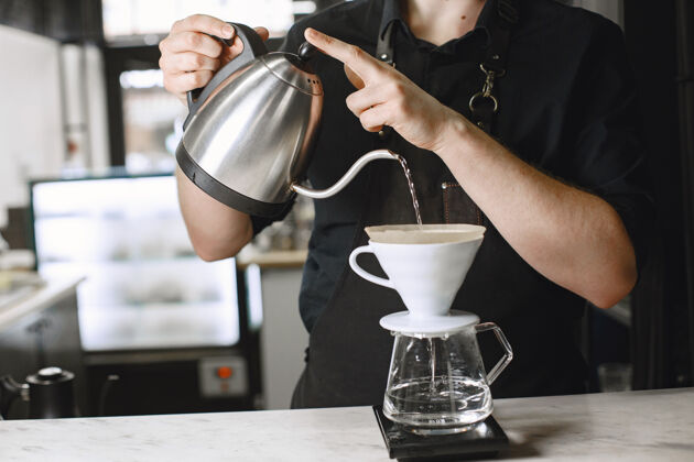 干黑咖啡咖啡师冲泡饮料咖啡在玻璃罐里水壶柜台员工