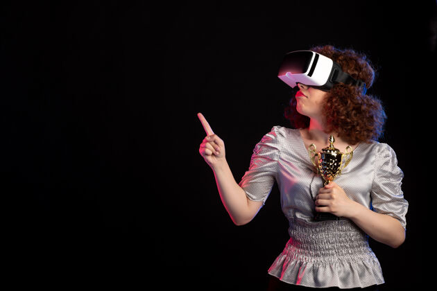 杯子年轻女性戴着vr耳机 深色表面有杯子黑暗虚拟现实游戏