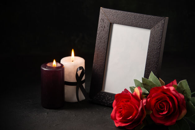 死亡在黑暗的表面上有红花和蜡烛的前视图画框战争火火焰