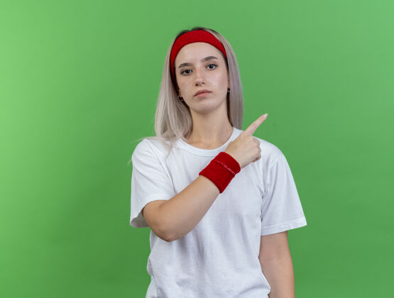 运动自信的年轻白人运动女孩戴着背带和头带壁板头带背带