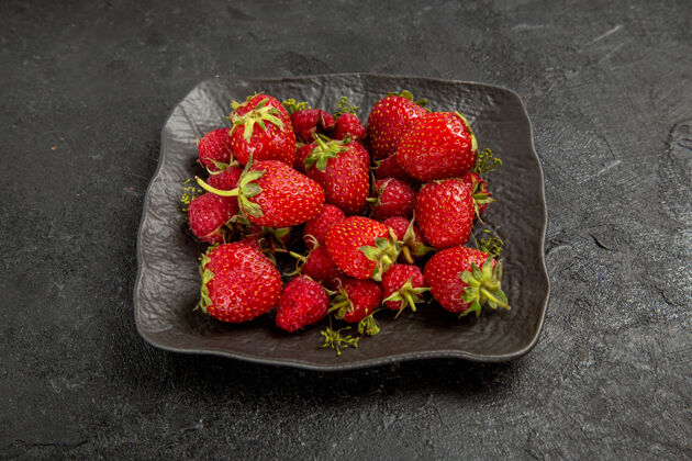 浆果前视图新鲜的红色草莓在黑暗的背景板内深色树水果