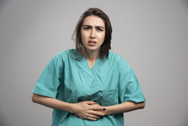 健康在灰色背景下 女医生胃痛高质量照片成人治疗制服