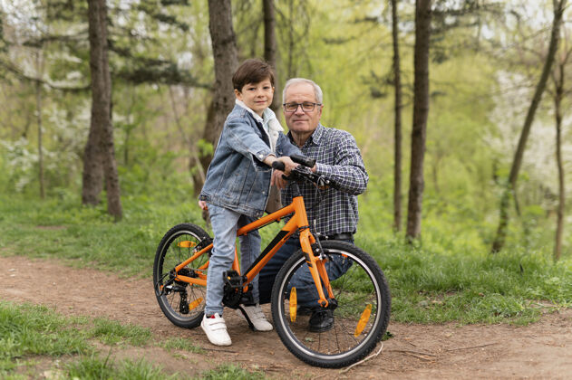 老人爷爷教他的孙子怎么骑自行车树人男孩