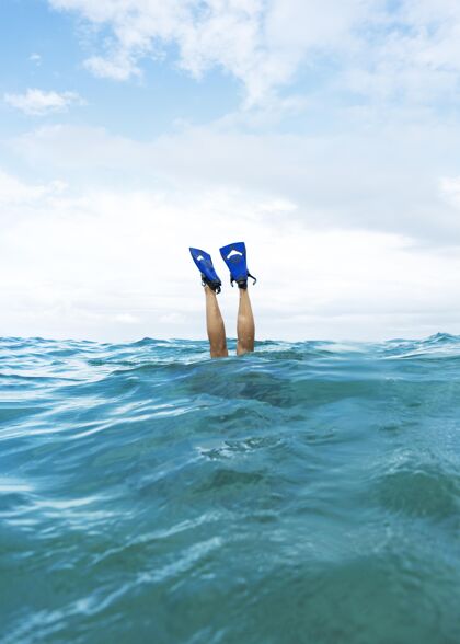 潜水在海里游泳的时候 穿着脚蹼的人把腿竖起来水上鳍状肢腿