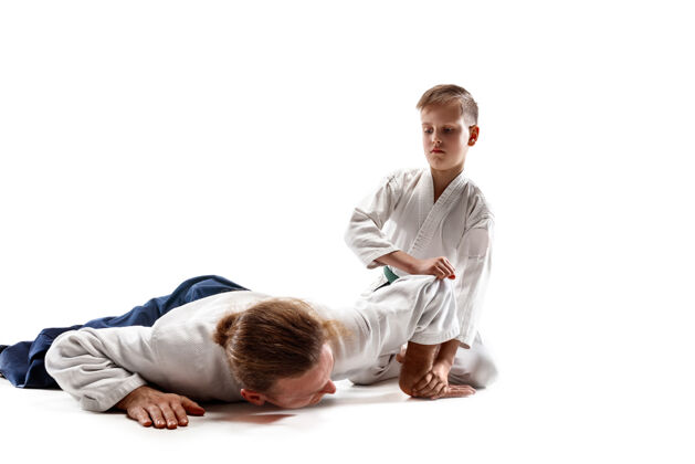 武术男子和少年男孩在武术学校的合气道训练战斗室内成人人