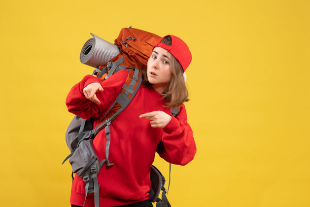 帽子正面图：站在黄色墙壁上 背着红色背包的年轻女旅行者乔伊背包站起来