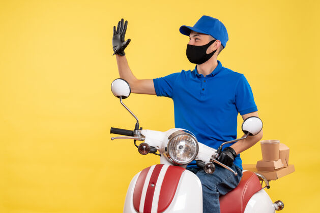 男人正面图黄色背景上穿着蓝色制服的年轻男性快递员职业大流行服务病毒自行车工作车辆病毒人