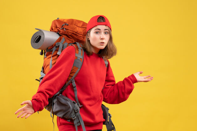 成人背着背包的年轻女旅行者的前视图让人困惑背包姿势困惑