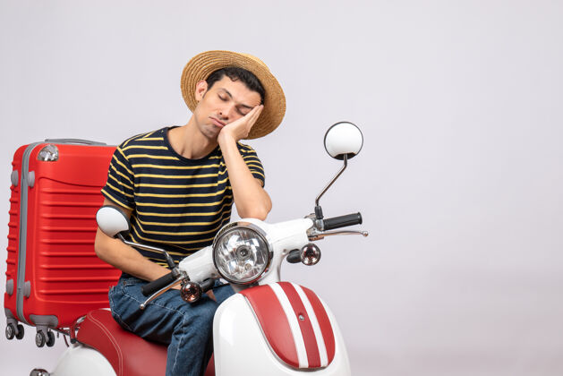 成人骑着轻便摩托车戴着草帽的昏昏欲睡的年轻人的正视图前面帽子轻便摩托车