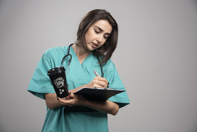 疾病年轻医生在剪贴板上写笔记高质量的照片医生女性职业