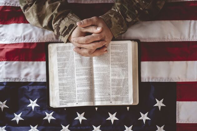 自由一名美国士兵在美国国旗和圣经面前哀悼和祈祷爱国超级英雄纪念