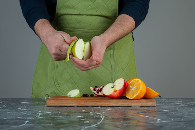 男男手在桌上的木板上剥新鲜苹果苹果混合厨师