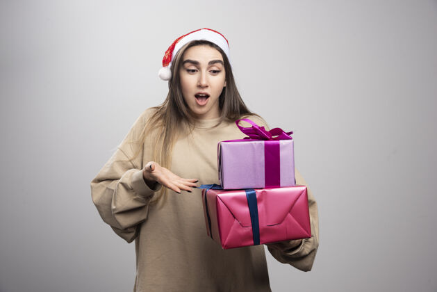 成人年轻女子看着两盒圣诞礼物红色女孩礼物