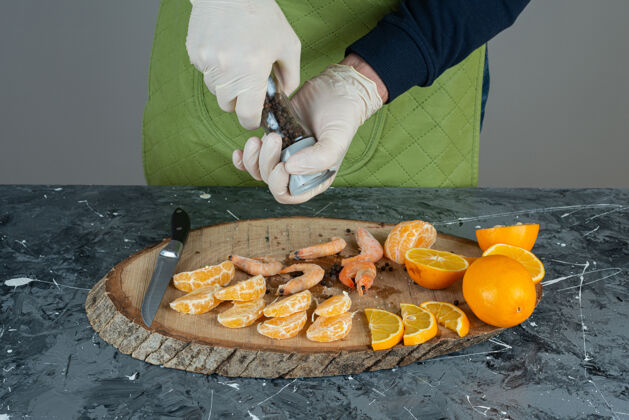 烹饪男人戴上手套 在大理石桌上给虾加盐虾水果手