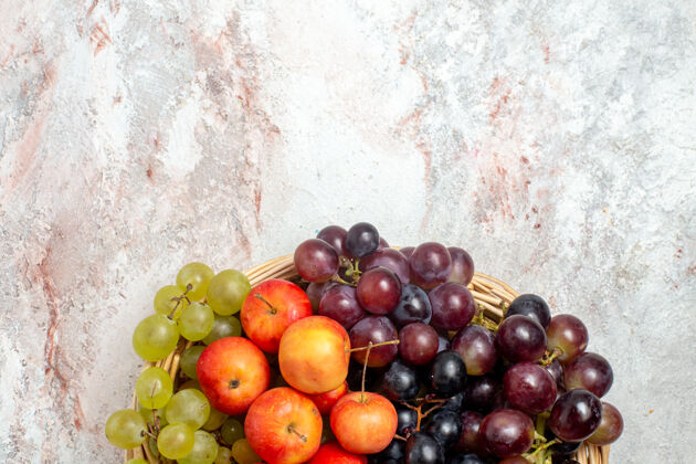 食物浅白色表面上有李子的新鲜葡萄俯视图葡萄新鲜水果