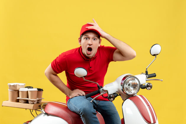 人俯视图是一个穿着红色上衣 戴着帽子 在黄色背景下传递命令的年轻人摩托车人黄色