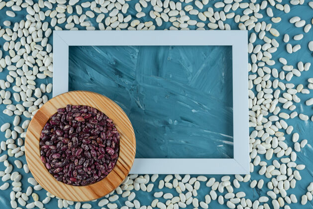 豆类一堆各种各样的生豆子散落在蓝色的背景和框架上背景健康有机