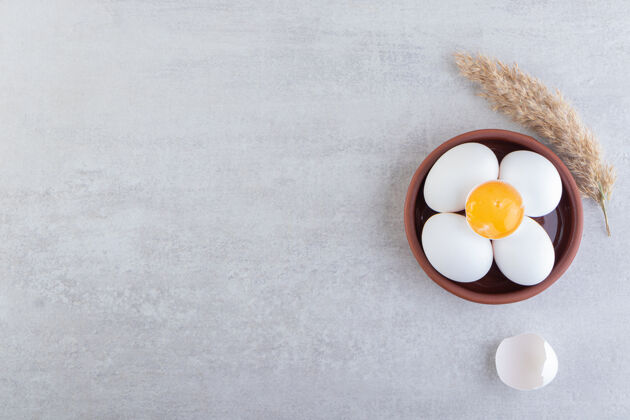 未经料理的生的新鲜的白色鸡蛋放在石头背景上鸡肉背景新鲜