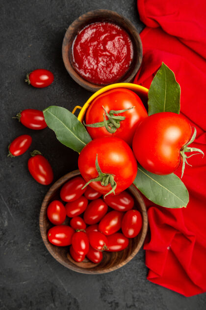 毛巾顶视图一桶西红柿和月桂叶碗樱桃西红柿和番茄酱和红毛巾在黑暗的地面上水果新鲜维管植物