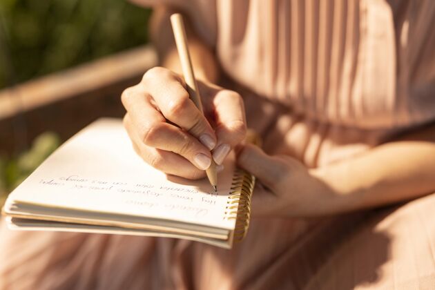成年人特写手写在笔记本上女性放松写作