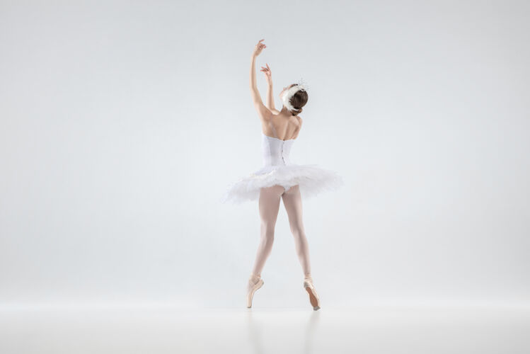 愉悦优雅的经典芭蕾舞演员在白色的工作室背景下跳舞穿着柔软衣服的女人像一只白天鹅优雅 艺术家 运动 动作和运动的概念看起来没有重量表演情侣性格