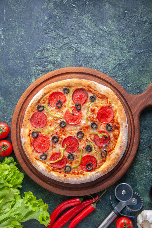 奶酪木制砧板上美味的自制比萨饼的垂直视图番茄酱绿色的包在黑暗的表面食物板一餐