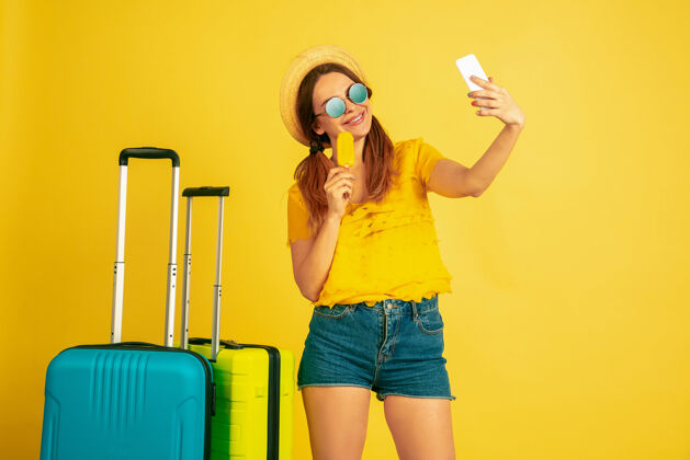 夏天旅行前自拍黄色工作室背景上的白种女人肖像帽子里的美丽模特人类情感的概念 面部表情 销售 广告夏日 旅游 度假衬衫帅哥一半