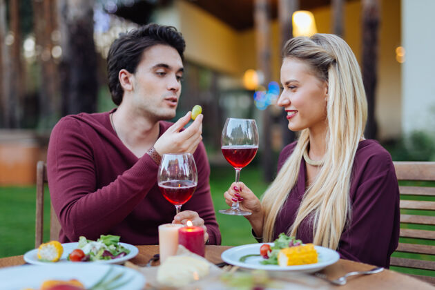 快乐浪漫的庆祝高兴的积极的夫妇坐在一起 在餐厅喝酒感觉食物浪漫