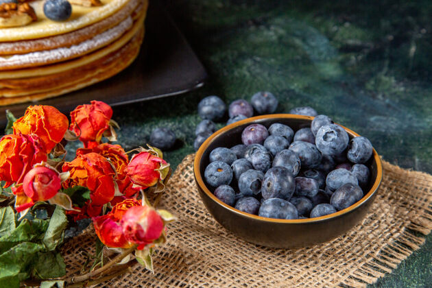 可食用水果正面是新鲜的蓝莓和美味的蜂蜜蛋糕深色的表面农产品新鲜蓝莓健康
