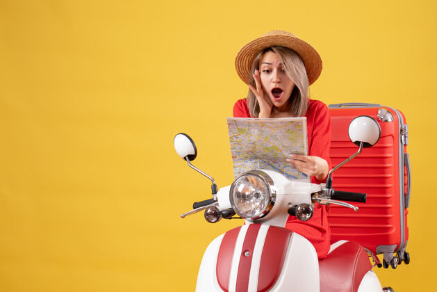车辆前视图惊艳美丽的女孩骑着轻便摩托车红色手提箱举行地图肖像轻便摩托车球