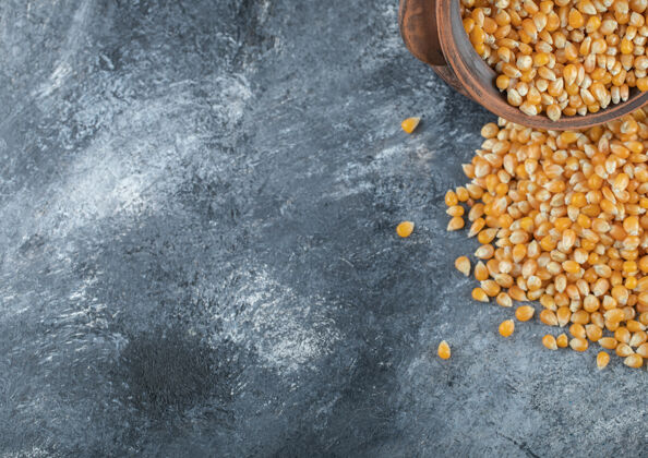 玉米一个盛满未煮熟的爆米花籽的古老碗爆米花黄色顶视图