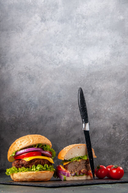 食物全切美味三明治和西红柿的垂直视图 黑色托盘上有干刀 深色混合色表面西红柿混合物桨