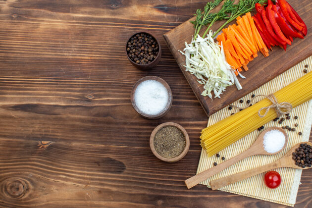 视图俯视切菜卷心菜胡萝卜青菜和胡椒在切菜板棕色表面胡萝卜膳食沙拉