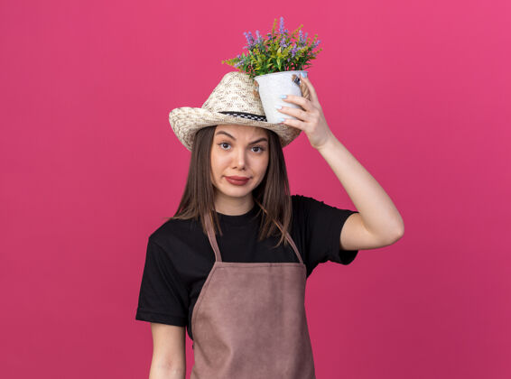 女的惹恼了漂亮的白人女园丁戴着园艺帽捧着花盆头顶粉红花园花盆园艺