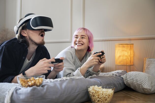 玩家一对年轻夫妇在玩虚拟现实游戏女人室内乐趣