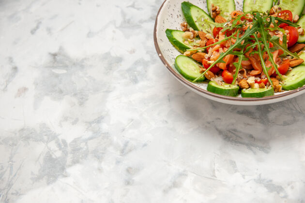 蔬菜顶部视图自制健康美味素食沙拉装饰切碎黄瓜在一个碗的左侧染色白色表面沙拉辣椒碗